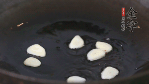 锅中油7成热时，下蒜瓣煸香。