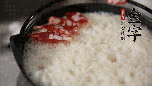 米饭出现小洞时，快速放入香肠片、姜丝。