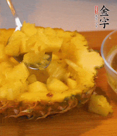 菠萝对半切开，切成小方格，用勺子把菠萝肉挖出来。用盐水稍浸泡。