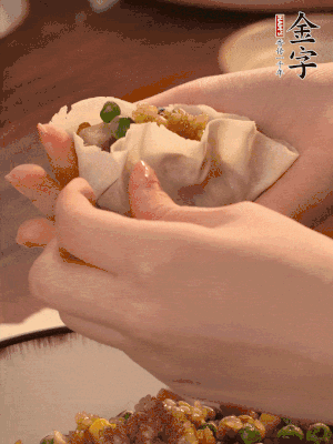 取一大勺馅料放进饺子皮里，用大拇指按住顶部馅料，再用虎口掐出形状。