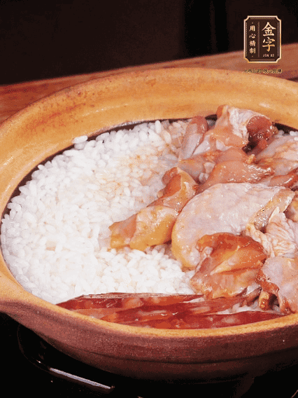 煮到椰子水微微收干转小火，快速均匀铺上鸡肉、金字香肠