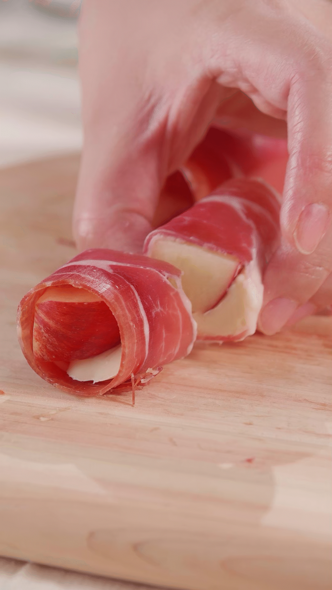 把卷好的火腿卷，对半切开